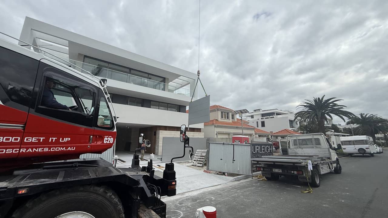 A crane lifts an custom automatic gate into place at an install on McIntosh Ilsand on the Gold Coast